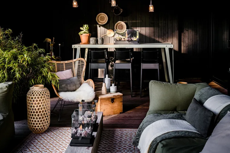 Door Milk&Sugar ingerichte donkere loungehoek met bank, planten en warme verlichting
